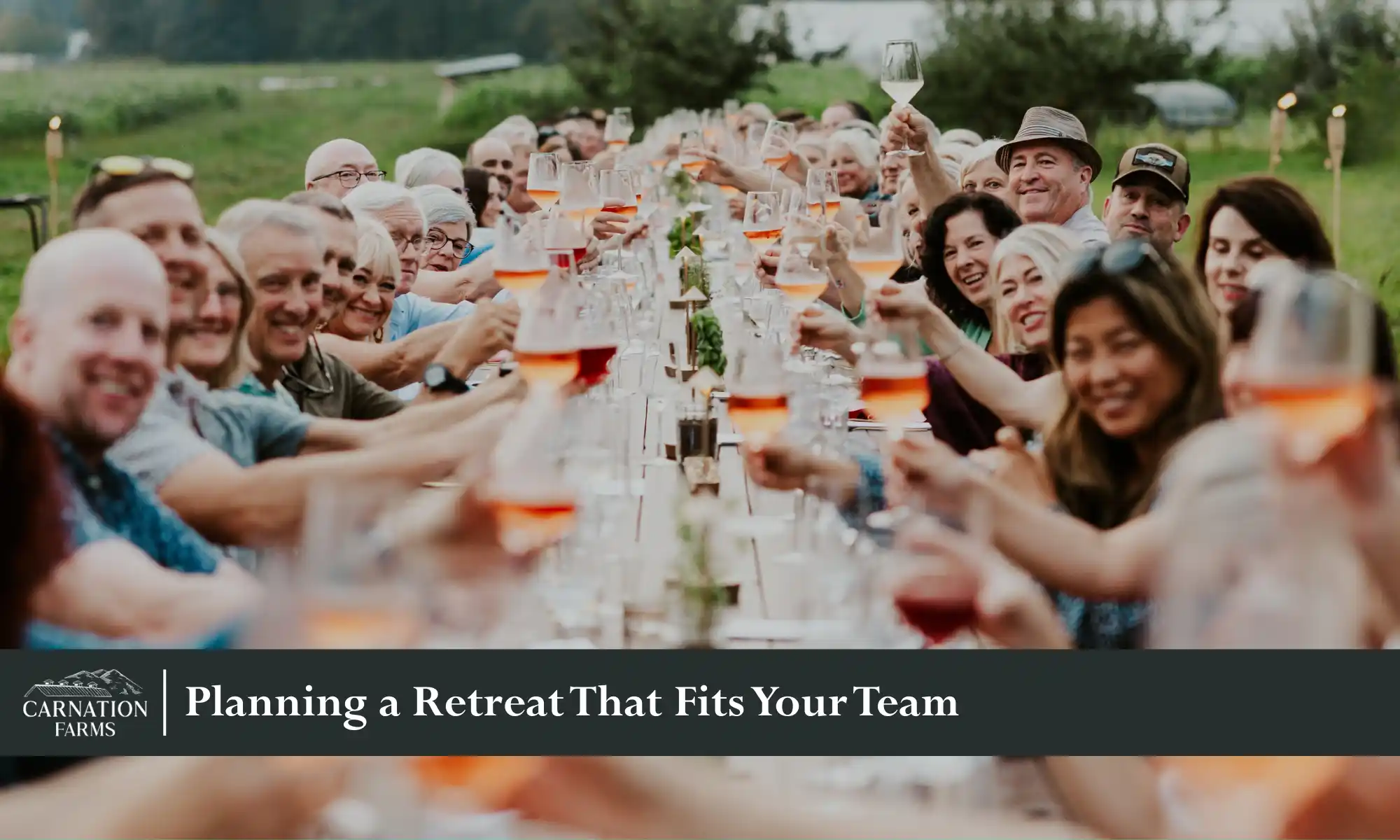 Corporate retreat group sharing a long outdoor dinner together.