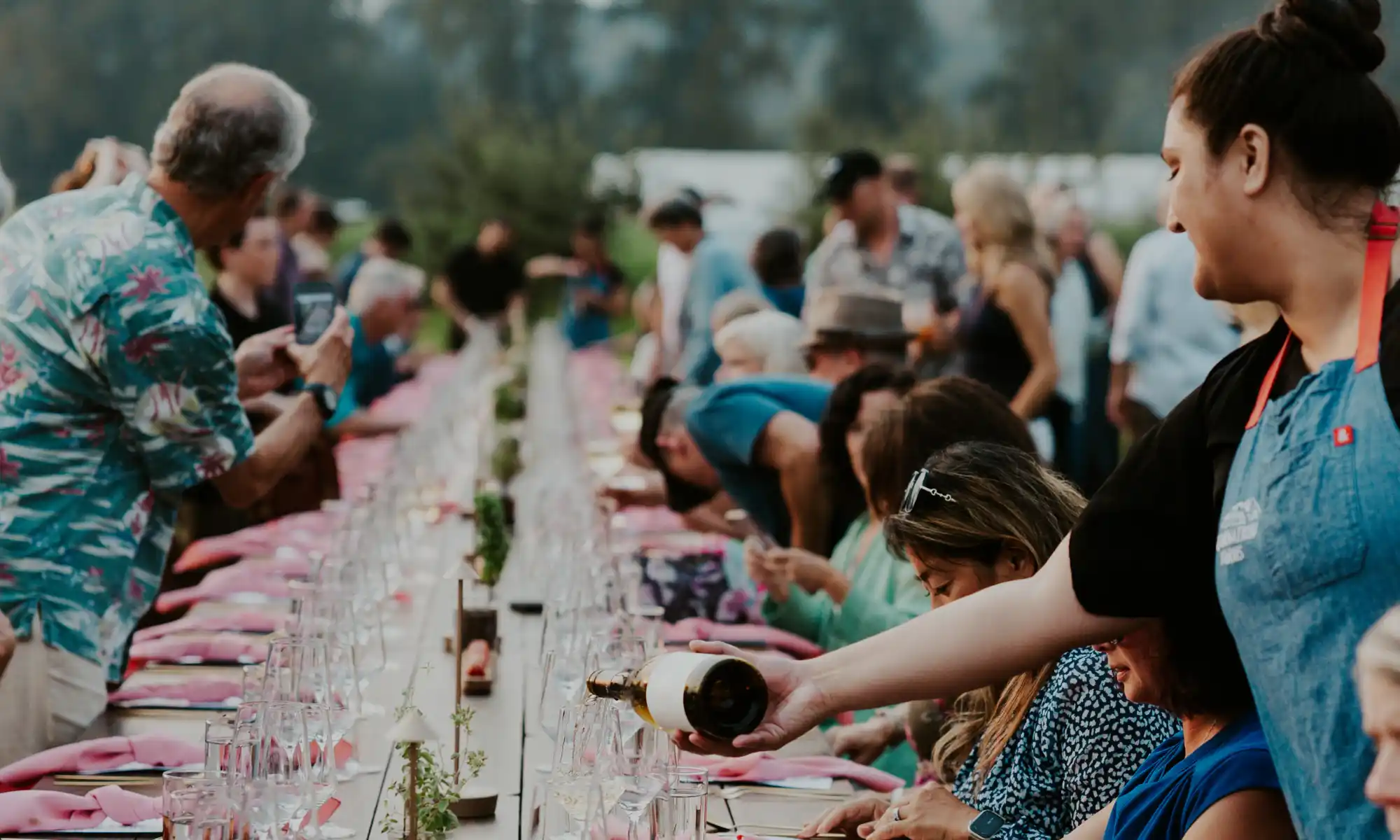 Corporate retreat group sharing a long outdoor dinner table experience.